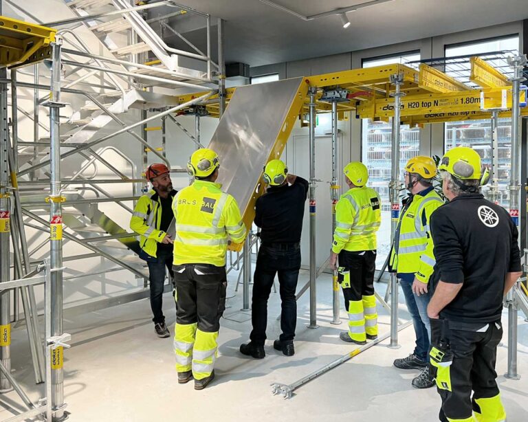 Mitarbeiter sehen sich ein Deckenschalungssystem an.