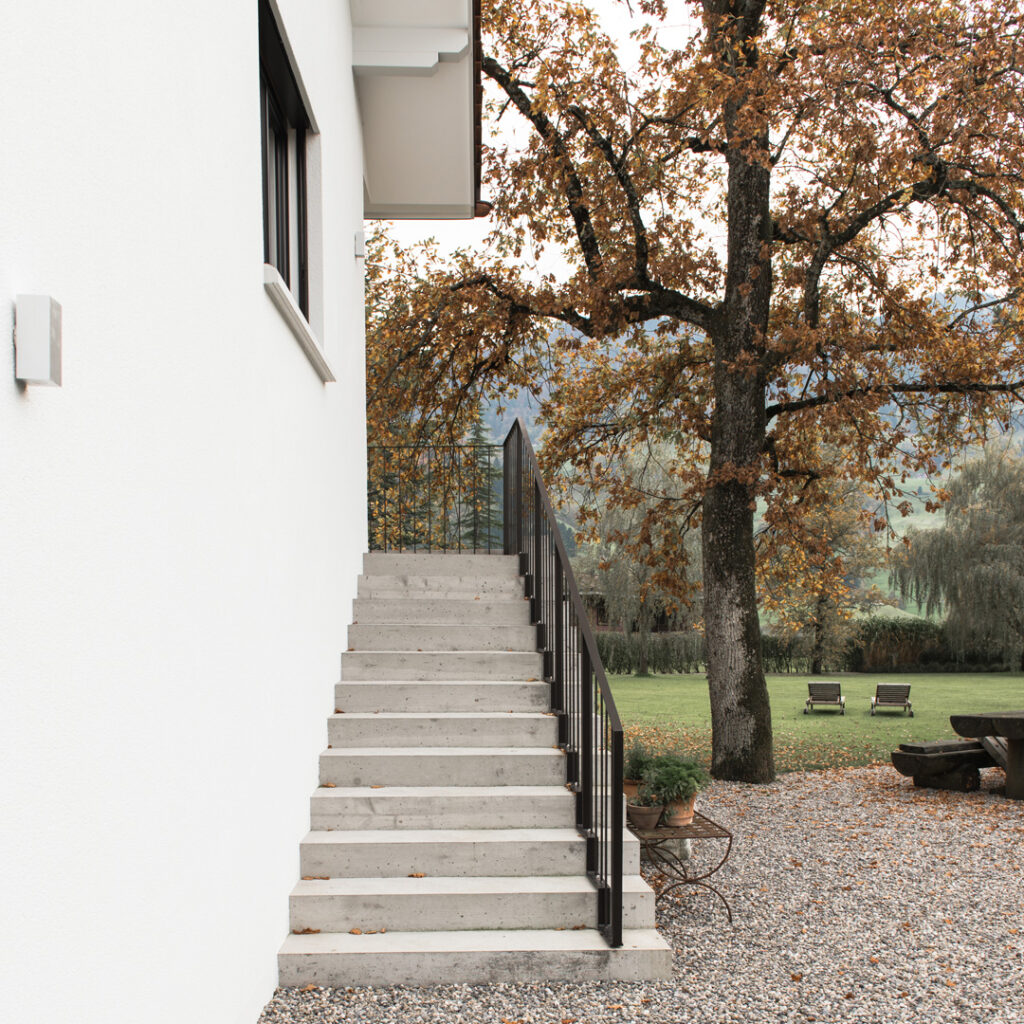 Betonierte Aussentreppe und Kiesplatz mit Garten