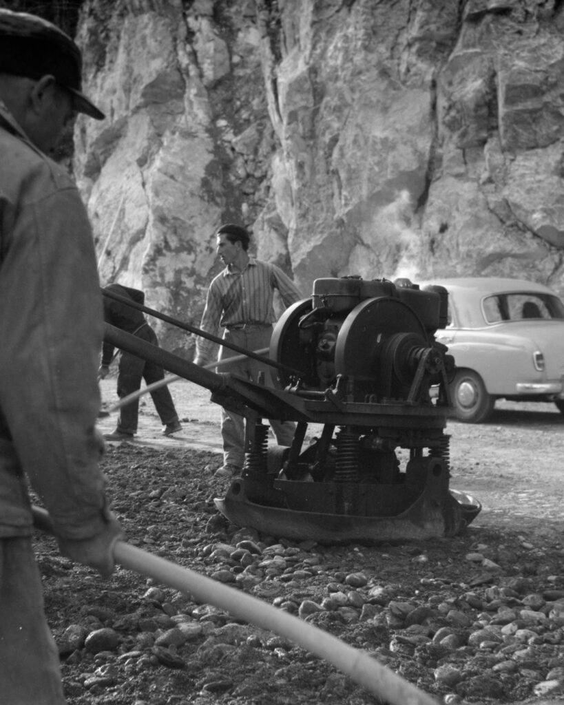 Archivbild schwarz-weiss Firma J.L. Brusa Bauunternehmung fertigt die Strasse entlang des Lauerzersees