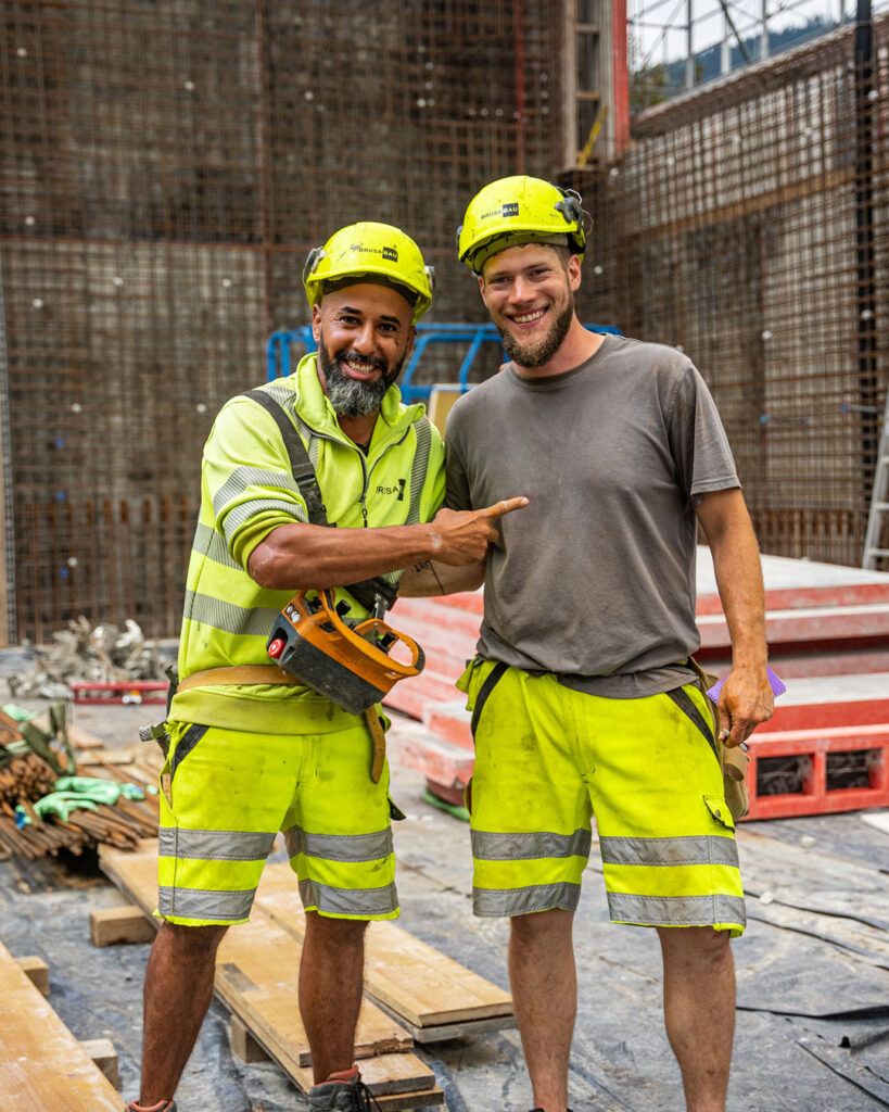 Glückliche Bauarbeiter lachen in die Kamera
