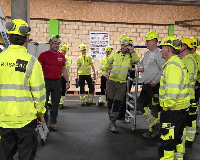 Mitarbeiter von Brusa Bau hören sich einen Vortrag zum Thema Arbeitssicherheit an.