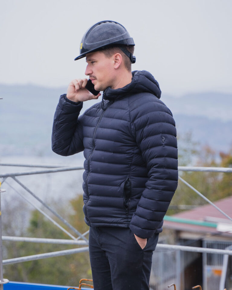 Ein Bauleiter telefoniert während eines Besuchs auf der Baustelle.