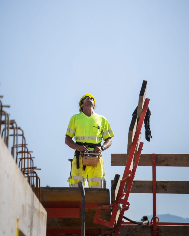 Ein Kranführer schaut gegen den Himmel um seinen Kran zu navigieren.