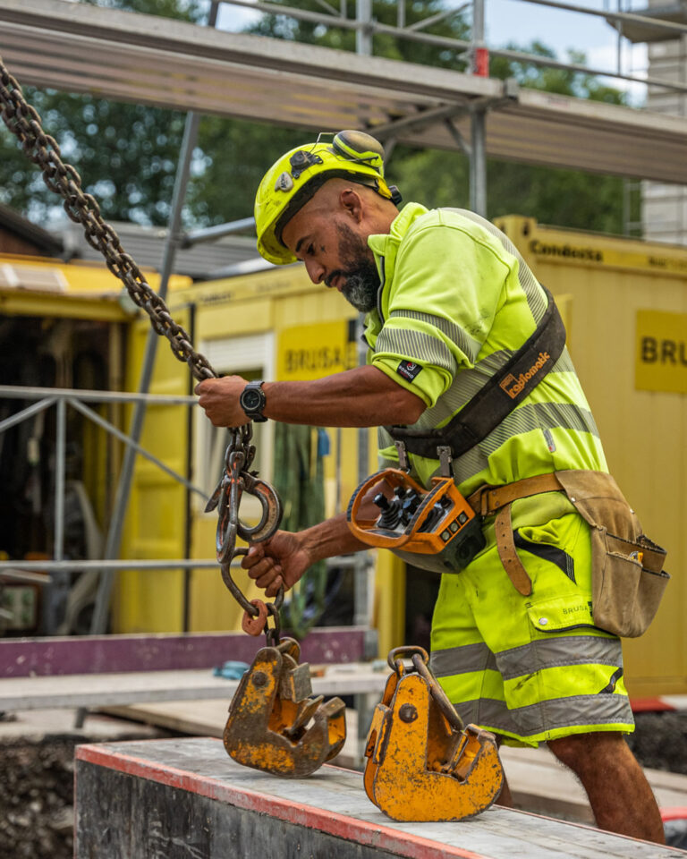 Der Kranführer befestigt ein Werkzeug am Kran.
