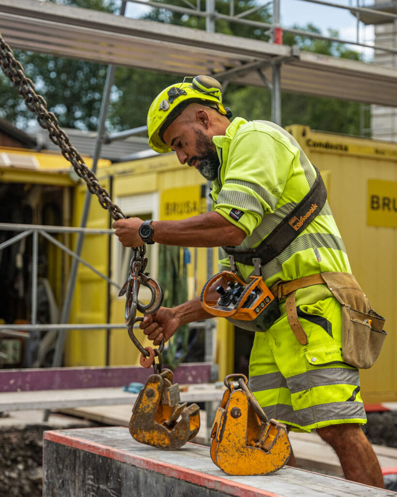 Der Kranführer befestigt ein Werkzeug am Kran.